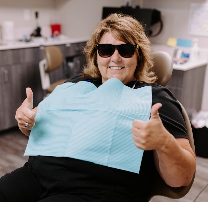 Woman giving two thumbs up in Brandon dental office