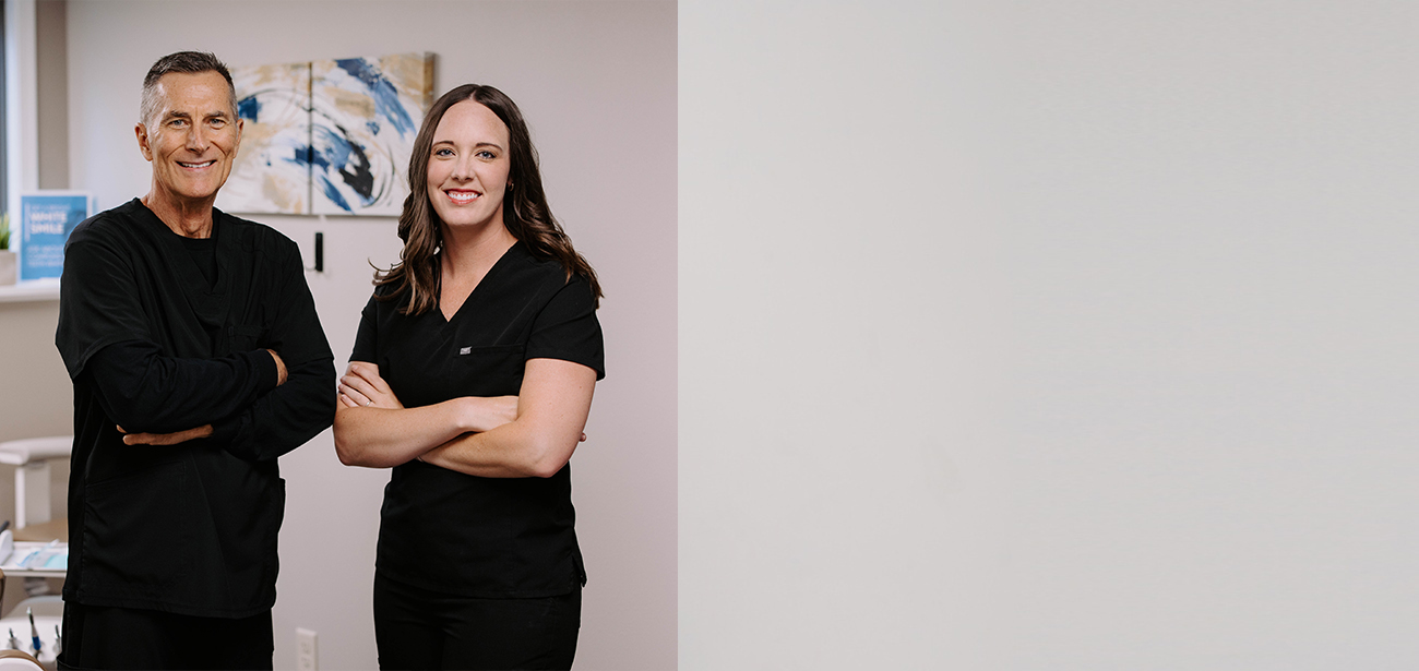 Two smiling Brandon dentists standing with arms crossed