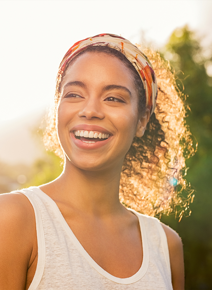 Woman smiling outdoors at sunset after cosmetic smile design in Brandon