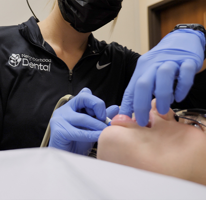 Dental team member giving a patient a teeth cleaning