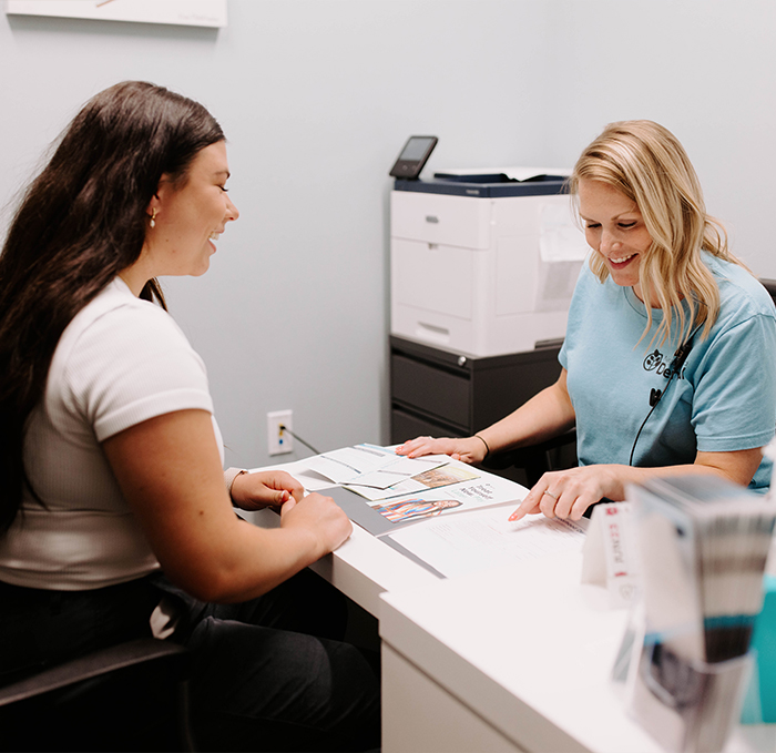 Dental team member talking to patient from across desk