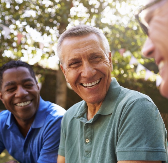 Three men laughing together outdoors