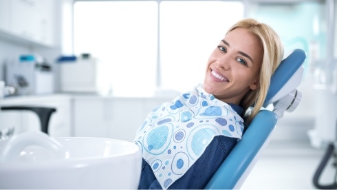 Smiling woman leaning back in dental chair