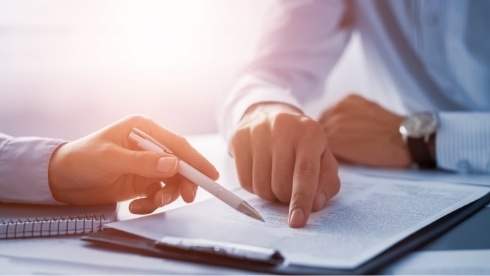 Two people looking at paper on clipboard