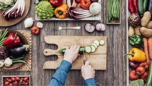 Person cutting cucumber on cutting board