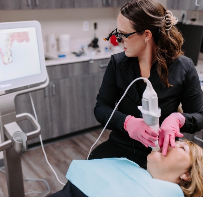 Dentist scanning teeth of patient with advanced cavity detection technology in Brandon