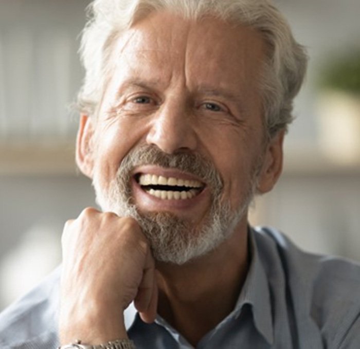 a man smiling after caring for his dentures 