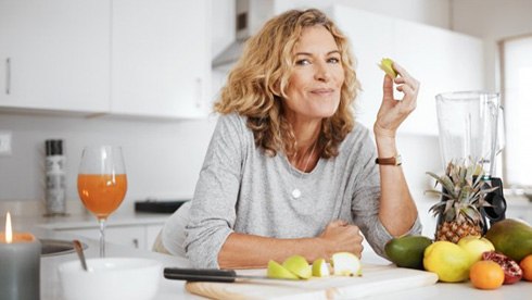 : a woman with dentures enjoying snacks at home