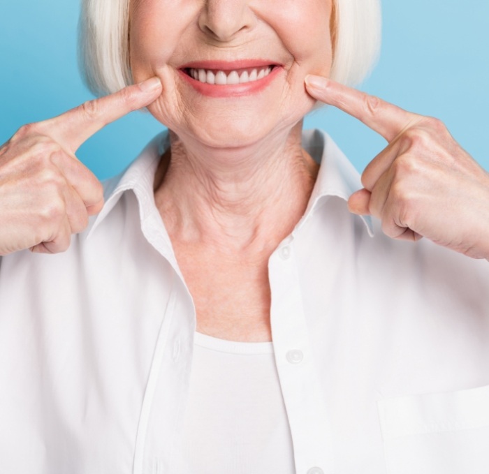 Senior woman pointing to her smile