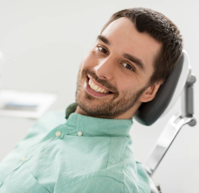 Smiling young man leaning back in dental chair
