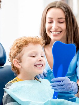 Child smiling in mirror after his checkup & cleaning