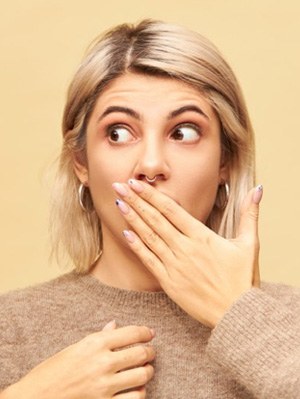 Patient holding her hand over her mouth