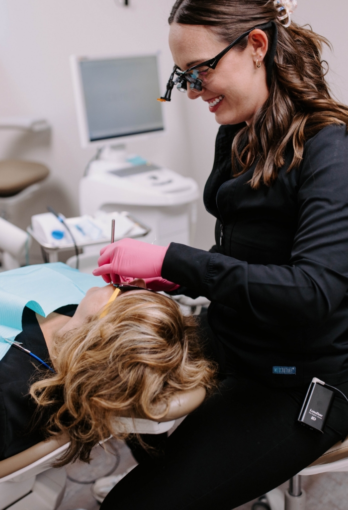 Doctor Heesch smiling while treating a dental patient