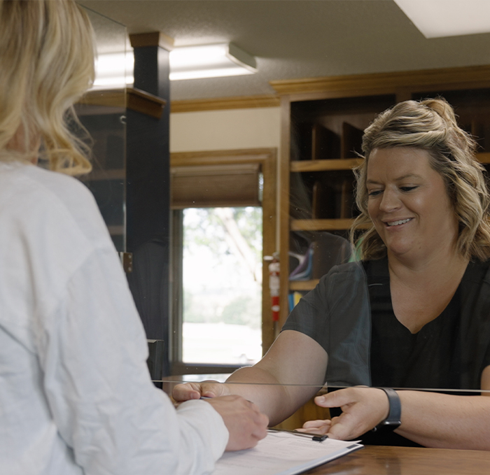 New Brandon dental patient talking to dental team member at front desk