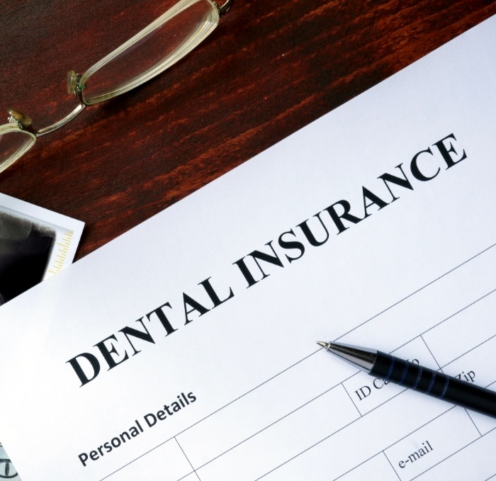 Dental insurance form on dark wood table