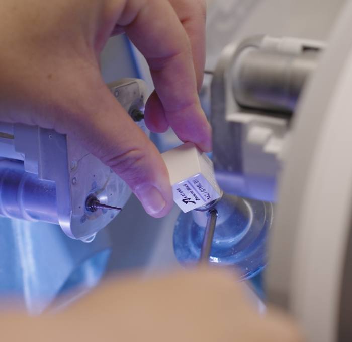 Dental team member placing small block of ceramic into C E R E C machine