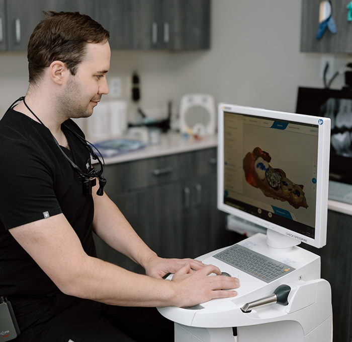 Dental team member placing small block of ceramic into C E R E C machine