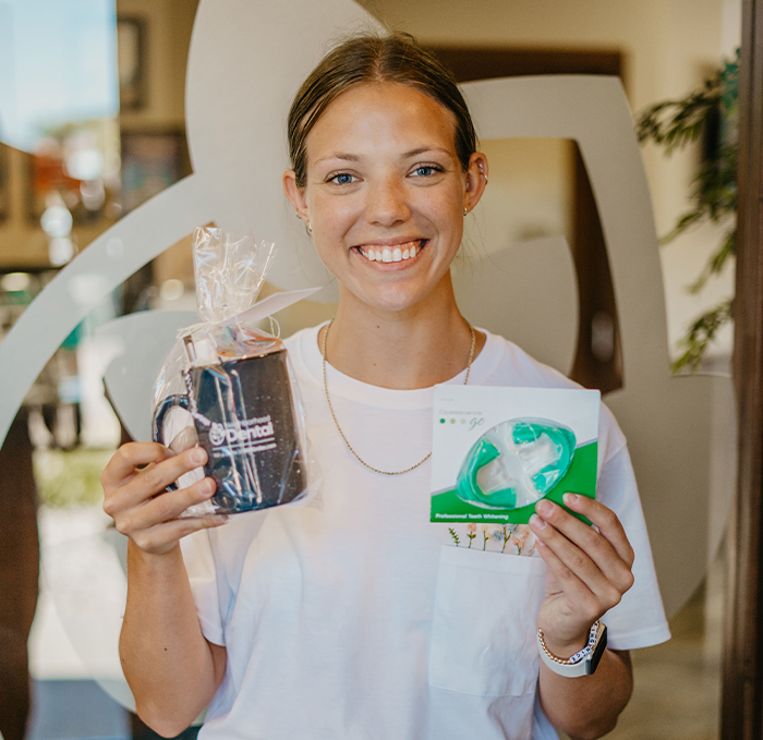 Woman holding coffee mug and teeth whitening trays