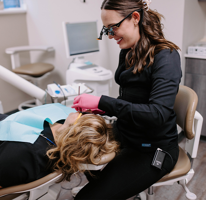 Cosmetic dentist smiling while preparing a patient for dental veneers in Brandon