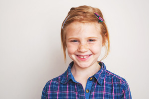 Close-up of little red-haired girl smiling