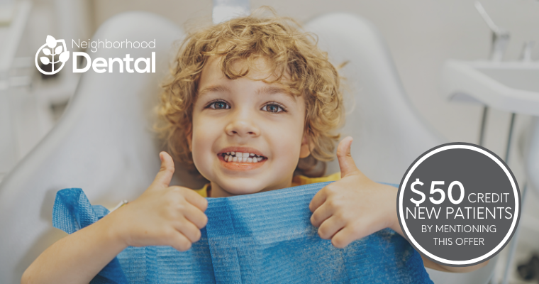 Smiling child with curly hair gives a thumbs-up at a dental office, wearing a blue dental bib. Text: 'Neighborhood Dental' and '$50 credit new patients'.